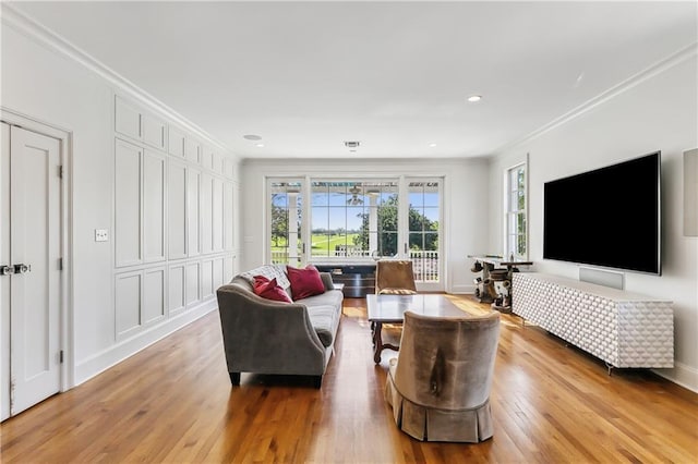 living room featuring crown molding and light wood-type flooring