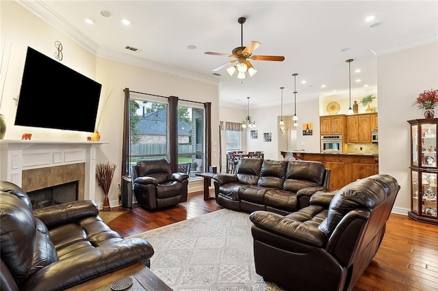 living room featuring a fireplace, crown molding, dark hardwood / wood-style flooring, and ceiling fan