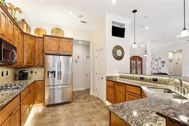 kitchen with tasteful backsplash, stainless steel appliances, crown molding, sink, and hanging light fixtures