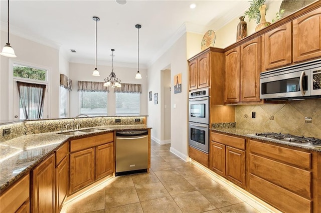 kitchen with sink, hanging light fixtures, decorative backsplash, dark stone countertops, and appliances with stainless steel finishes