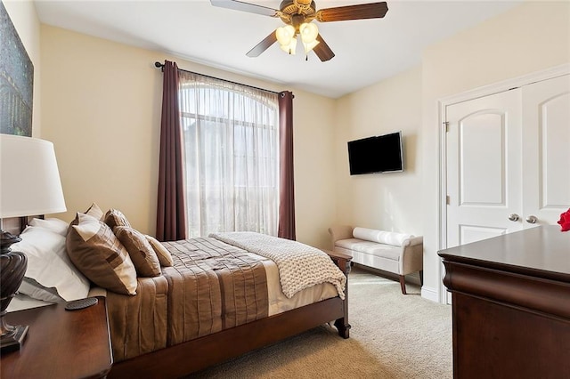 bedroom featuring ceiling fan, a closet, and light colored carpet