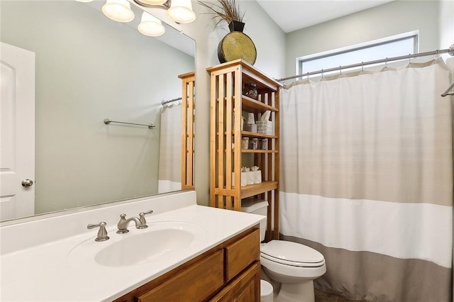 bathroom featuring a shower with shower curtain, vanity, and toilet