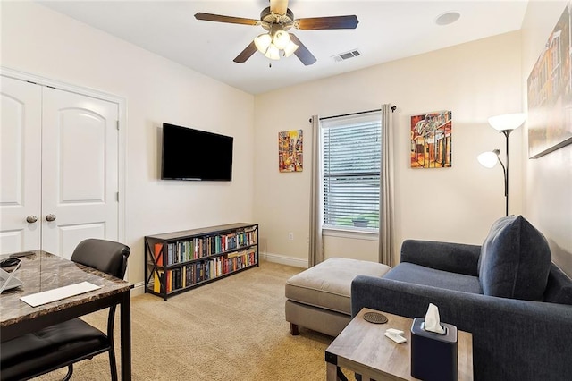 carpeted living room featuring ceiling fan