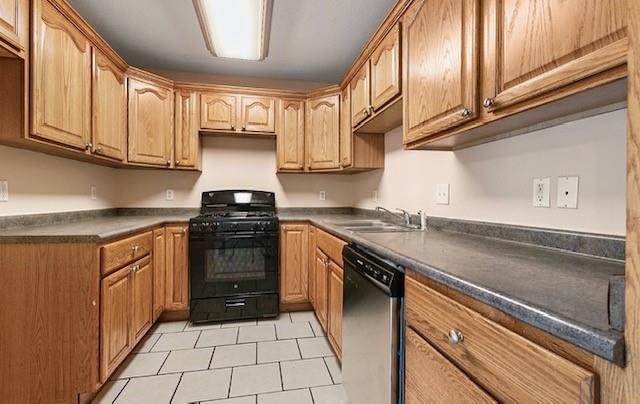 kitchen featuring dishwasher, black range with gas cooktop, light tile patterned flooring, and sink