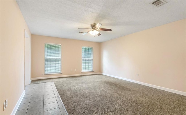 carpeted empty room featuring ceiling fan and a textured ceiling