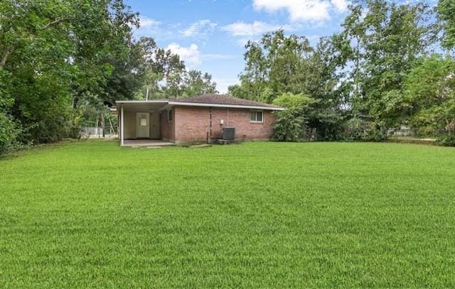 back of house featuring cooling unit and a lawn