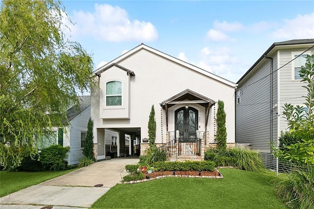 view of front of house featuring a front lawn, stucco siding, french doors, driveway, and a carport