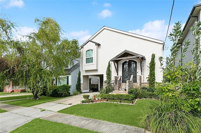 view of front facade featuring stucco siding, driveway, and a front lawn