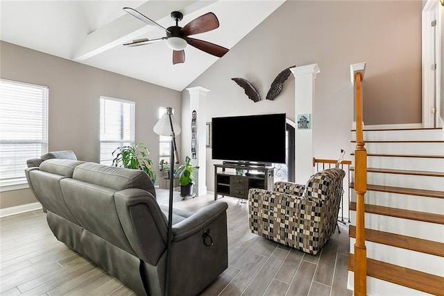 living area with a ceiling fan, baseboards, vaulted ceiling, stairs, and wood tiled floor