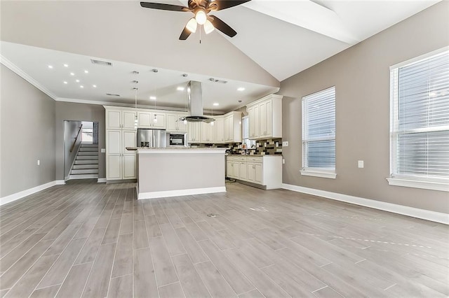 kitchen featuring open floor plan, a kitchen island, hanging light fixtures, and stainless steel fridge with ice dispenser