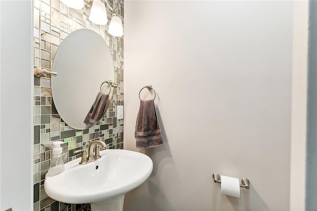 bathroom with a sink, tile walls, and decorative backsplash