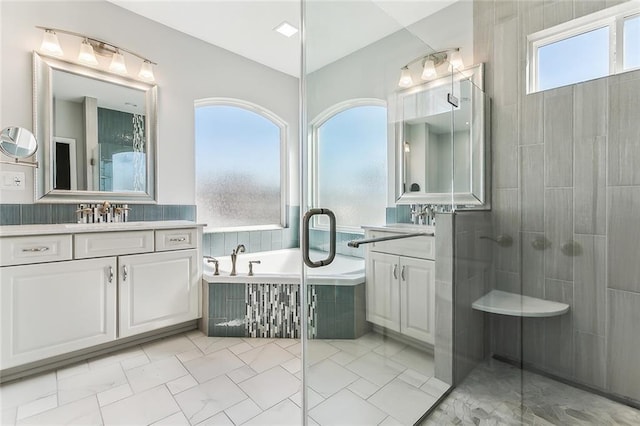 full bath with a sink, a bath, two vanities, and a tile shower