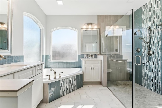 full bath with a garden tub, a stall shower, and vanity