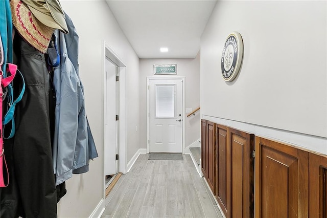 doorway to outside with light wood-type flooring and baseboards