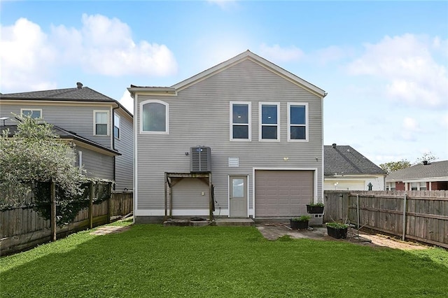 rear view of property featuring a lawn, an attached garage, and a fenced backyard