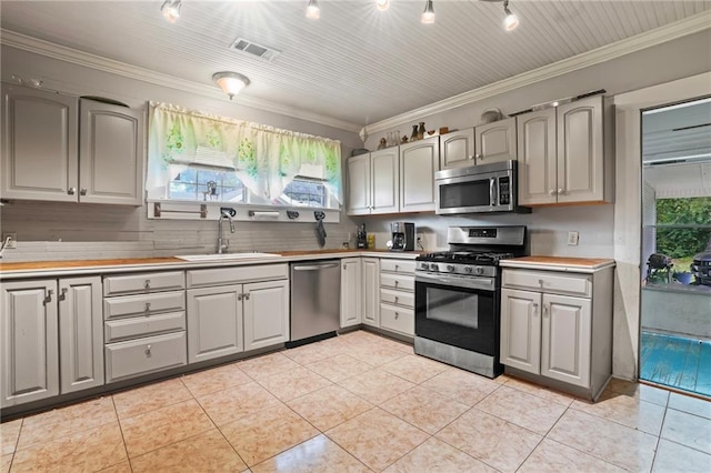 kitchen featuring ornamental molding, sink, appliances with stainless steel finishes, and tasteful backsplash