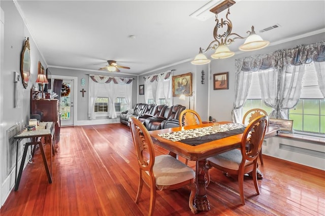 dining space featuring ceiling fan, ornamental molding, and hardwood / wood-style flooring