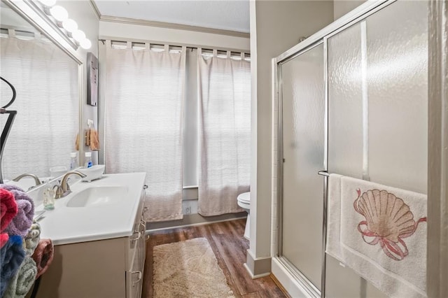 bathroom with vanity, toilet, wood-type flooring, and ornamental molding