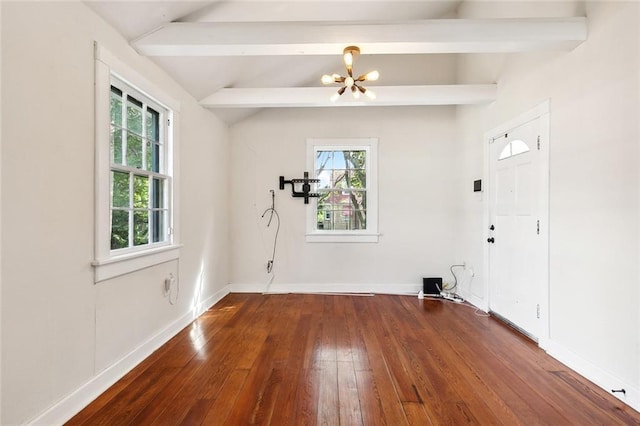 spare room with a chandelier, dark hardwood / wood-style flooring, lofted ceiling with beams, and a healthy amount of sunlight