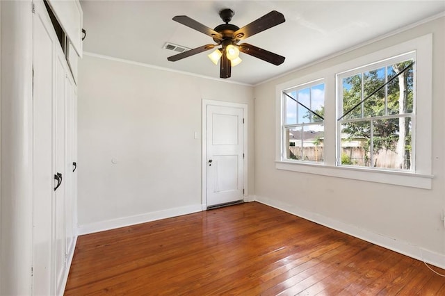 unfurnished bedroom featuring ceiling fan, hardwood / wood-style floors, and ornamental molding