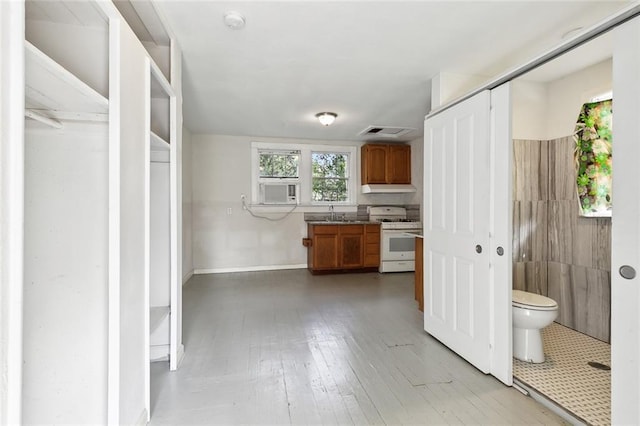 interior space with white range with gas cooktop, cooling unit, and sink