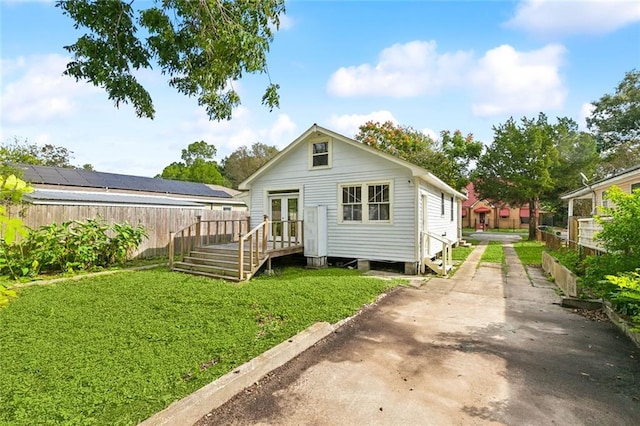 back of house with a yard and french doors