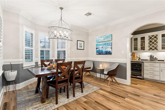 living room with ceiling fan, a fireplace, ornamental molding, and light wood-type flooring