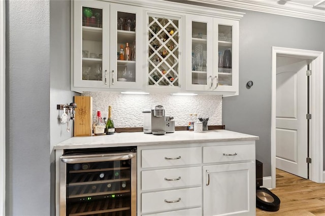 kitchen featuring sink, light hardwood / wood-style flooring, appliances with stainless steel finishes, decorative light fixtures, and white cabinetry