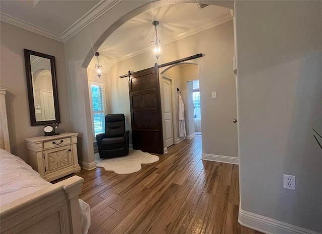 bedroom featuring a barn door, dark hardwood / wood-style flooring, and ornamental molding