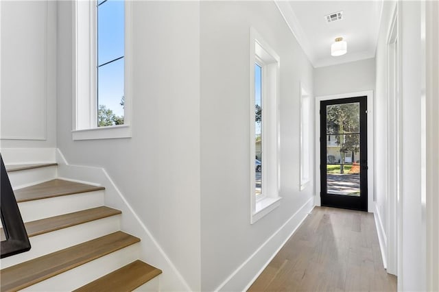 foyer entrance featuring light hardwood / wood-style flooring and crown molding