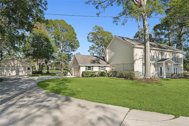 view of side of property with a garage, a yard, and an outdoor structure