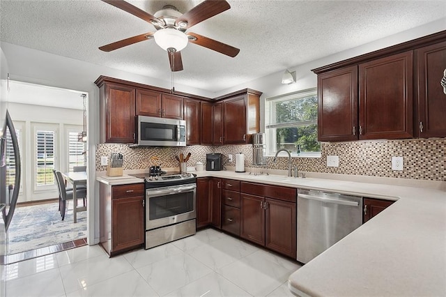 kitchen featuring sink, decorative backsplash, a wealth of natural light, and stainless steel appliances