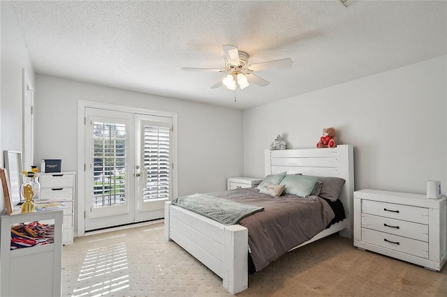 carpeted bedroom with access to exterior, french doors, a textured ceiling, and ceiling fan