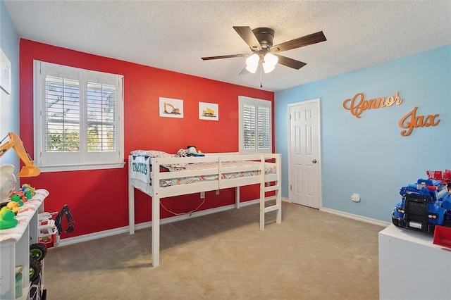 bedroom featuring ceiling fan, a textured ceiling, and carpet flooring