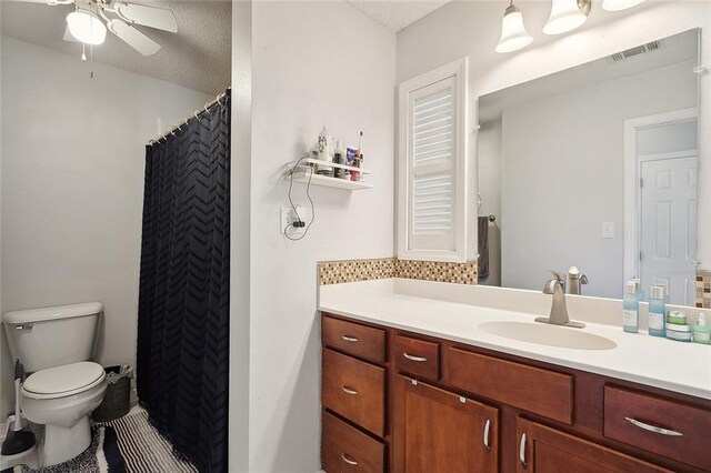 bathroom with toilet, ceiling fan, backsplash, a textured ceiling, and vanity