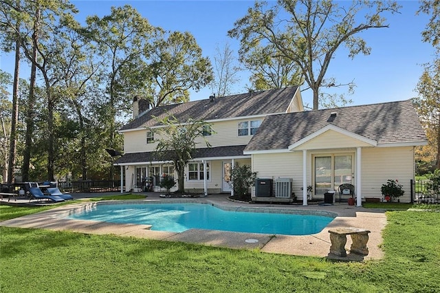 back of property featuring a fenced in pool, a lawn, and a patio area