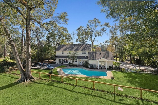 rear view of house with a patio and a yard