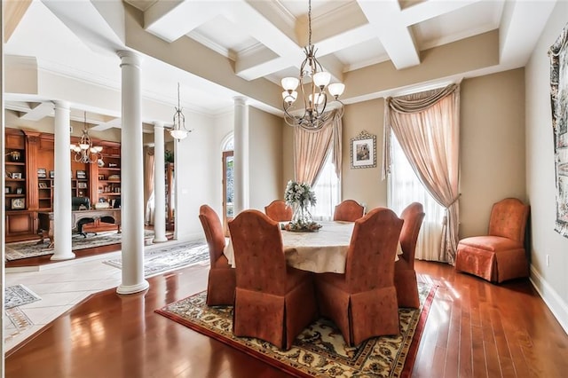 dining room featuring hardwood / wood-style flooring, ornate columns, and a notable chandelier