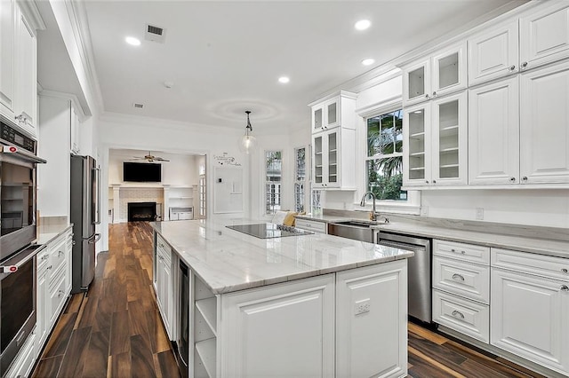 kitchen with hanging light fixtures, a center island, white cabinets, and stainless steel appliances