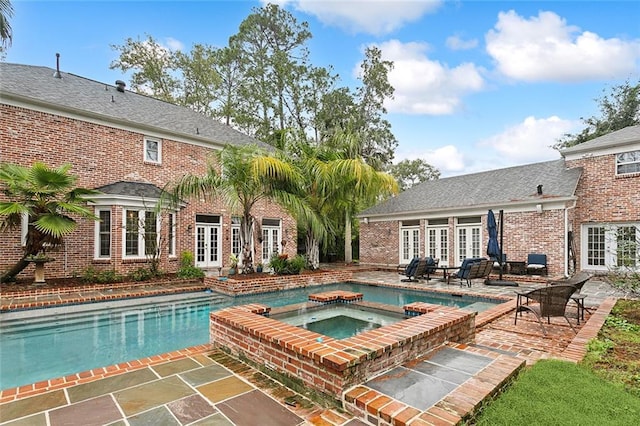 view of pool with an in ground hot tub, french doors, and a patio