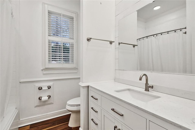 bathroom with wood-type flooring, vanity, and toilet