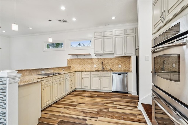 kitchen featuring dishwasher, pendant lighting, light hardwood / wood-style floors, and crown molding