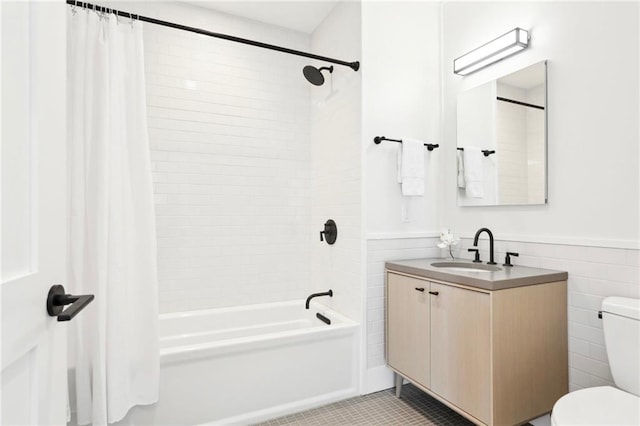 full bathroom with shower / bathtub combination with curtain, tile patterned floors, toilet, vanity, and tile walls