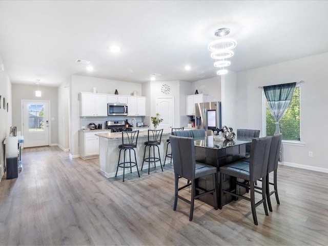 24440 Dawson Ct, Ponchatoula, LA 70454 - dining space with light wood finished floors, baseboards, recessed lighting, and a chandelier