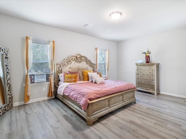 bedroom with light hardwood / wood-style flooring and multiple windows