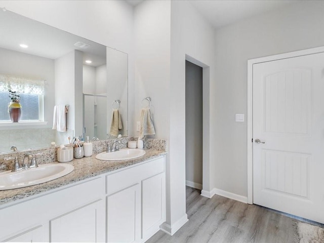 bathroom featuring hardwood / wood-style flooring, vanity, and an enclosed shower