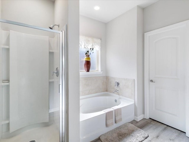 bathroom with wood-type flooring and separate shower and tub