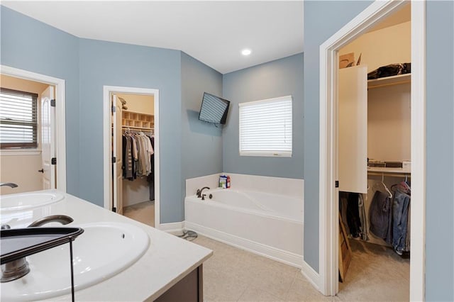 bathroom with tile patterned flooring, vanity, and a tub