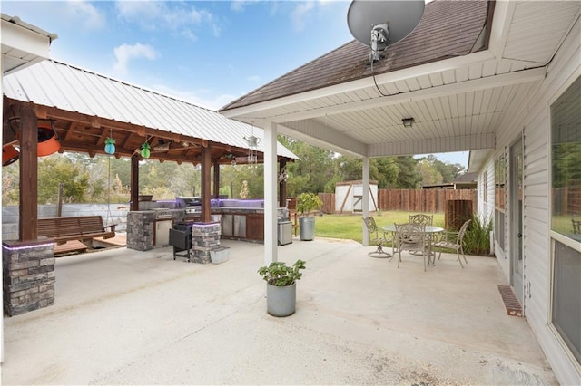 view of patio / terrace with a gazebo, a storage shed, and a hot tub