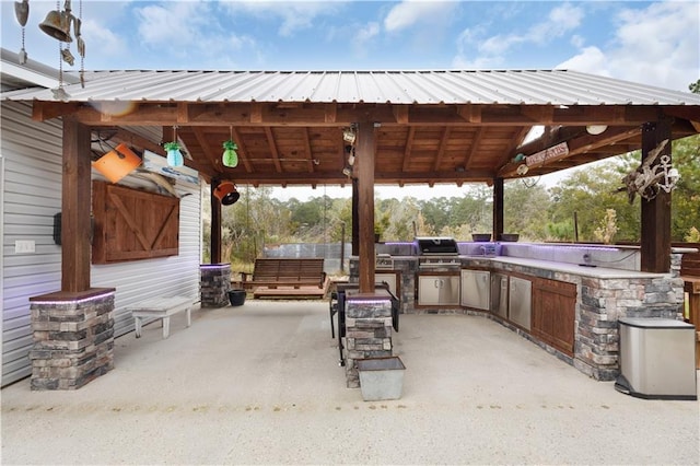 view of patio featuring a gazebo, grilling area, and exterior kitchen